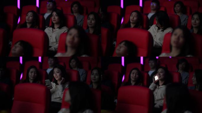 在电影放映期间，一名亚裔中国女性在黑暗中打电话，忽视和打扰周围的其他观众