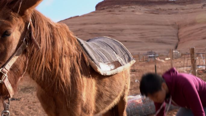 亚利桑那州纪念碑谷纳瓦霍部落公园附近，美丽的十几岁短发纳瓦霍族女孩骑着马鞍和马鞍毯