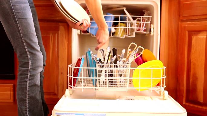 一个女人在卸洗碗机