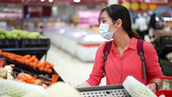 亚洲女性戴防护面具在超市购物