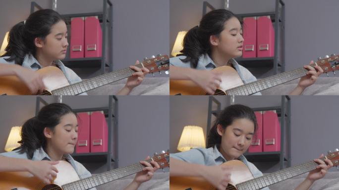 微笑的少女在家的客厅里弹原声吉他。创造性爱好
