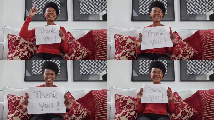 一位女士在视频通话中展示写有“谢谢”的论文-网络摄像头视角