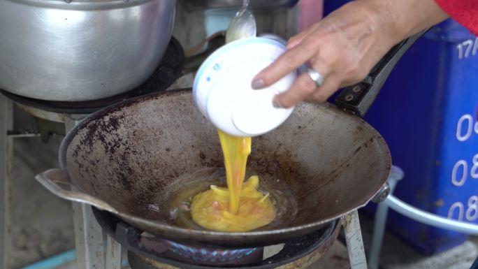 街头美食，厨师在泰国菜市场手工烹饪泰式煎蛋饼（khai Jiao）