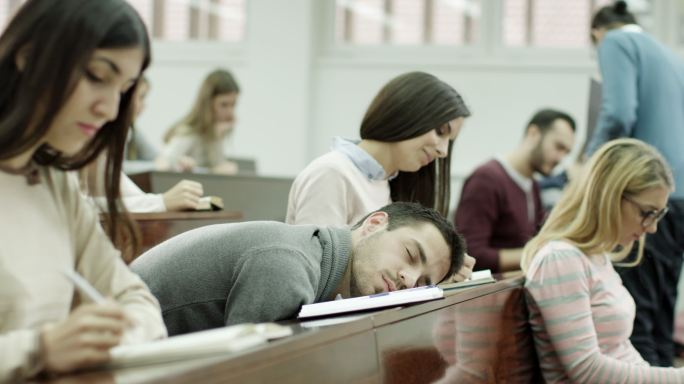 男生睡在教室里打盹大学教室大学生