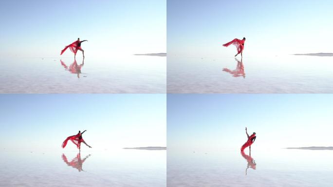 美丽的芭蕾舞演员戴着红色薄纱在湖面上跳舞