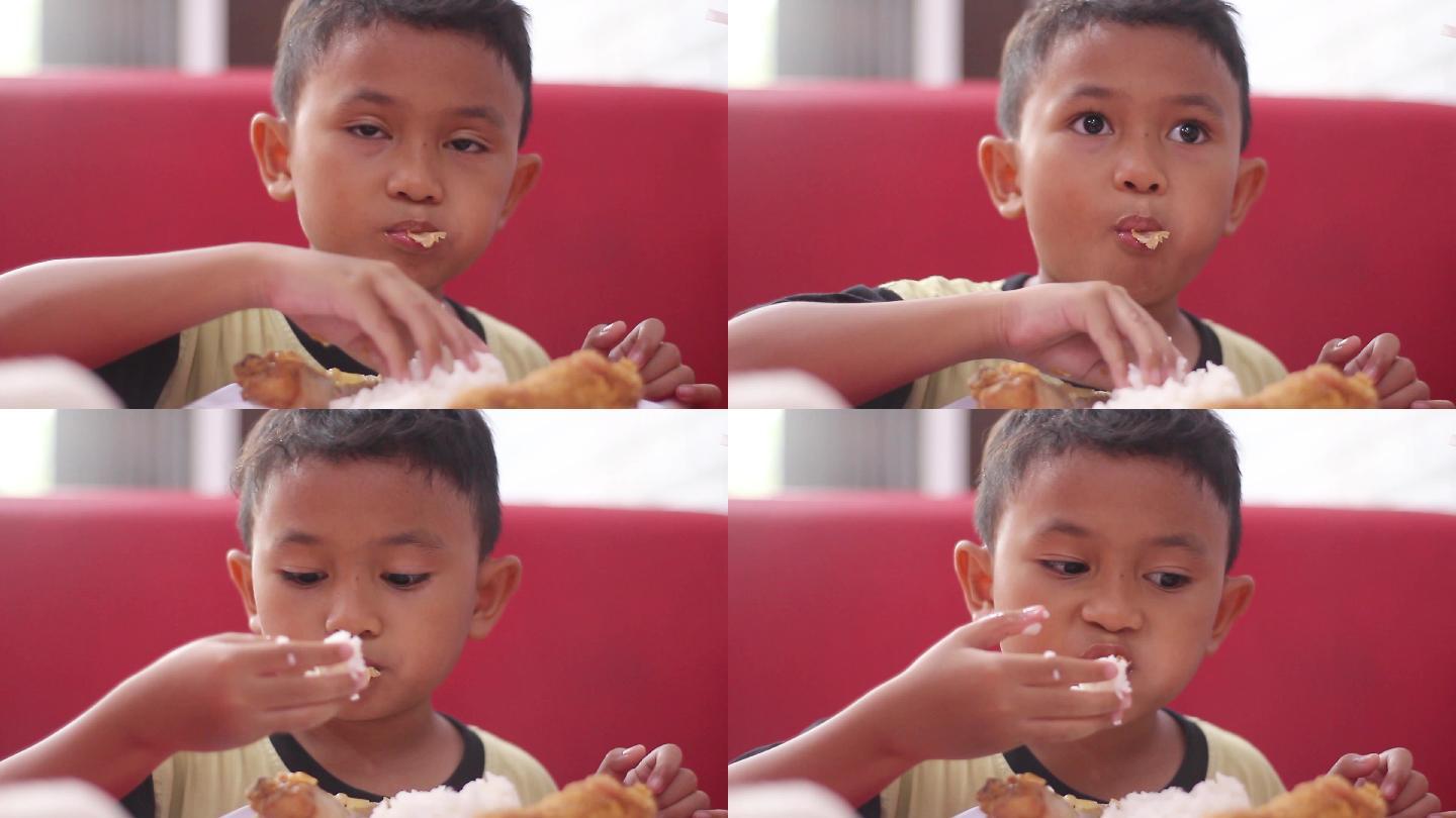 小男孩用手吃米饭和鸡肉