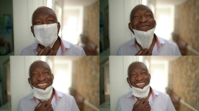 一位老人摘下面罩微笑的肖像