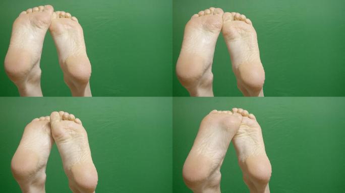 在绿色色度的关键背景下，在皮肤科治疗SPA过程中，女性脚的特写镜头。