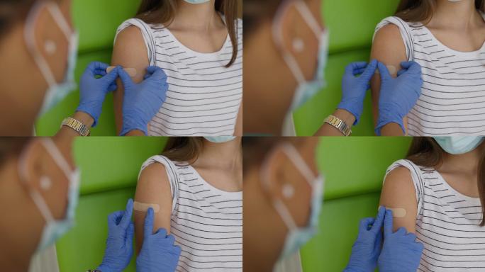 接种新冠肺炎疫苗后，护士在少女手臂上贴上创可贴