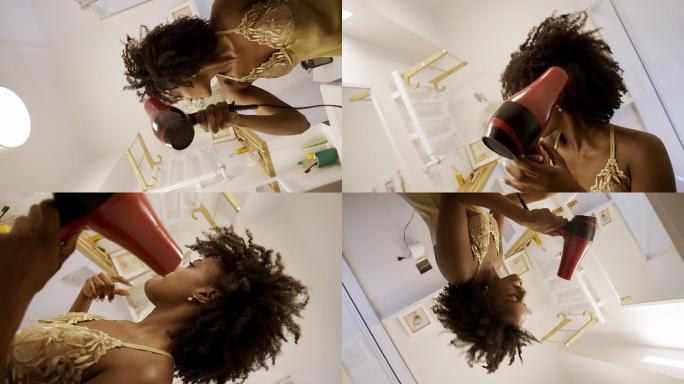 感觉棒极了。非洲裔女性享受早上的浴室常规，在镜子前玩得很开心。吹干头发跳舞
