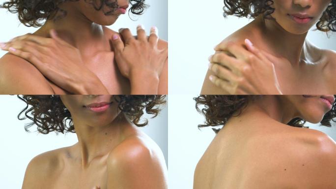 肩部特写正面图：亚洲美丽的棕褐色女性在白色背景上涂抹乳液。美丽、健康、情感观的人