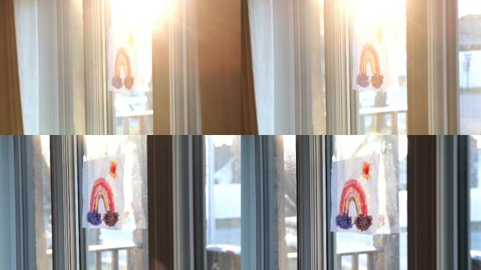 日落时分，在新冠肺炎危机期间，一条彩虹在家窗户上绘制的4K视频