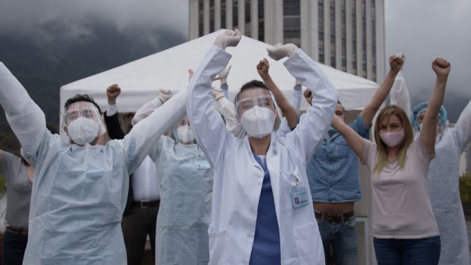 一线工作人员和患者高举双臂庆祝接种了新冠肺炎疫苗