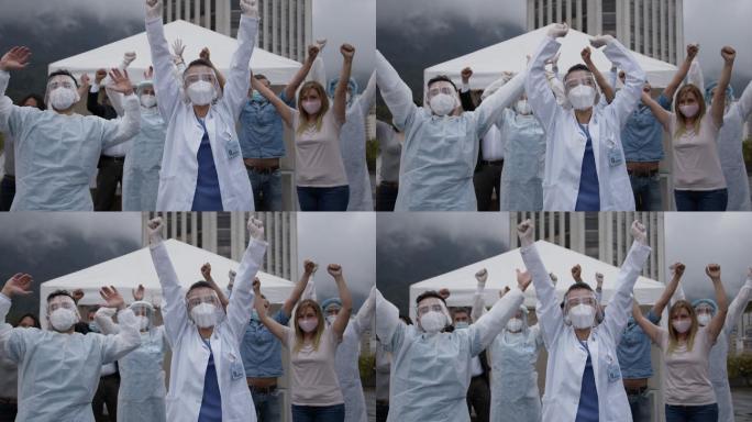 一线工作人员和患者高举双臂庆祝接种了新冠肺炎疫苗