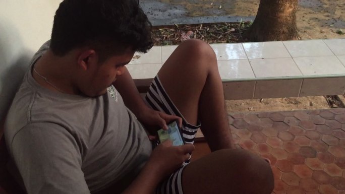 亚洲年轻男子在智能手机上玩视频游戏