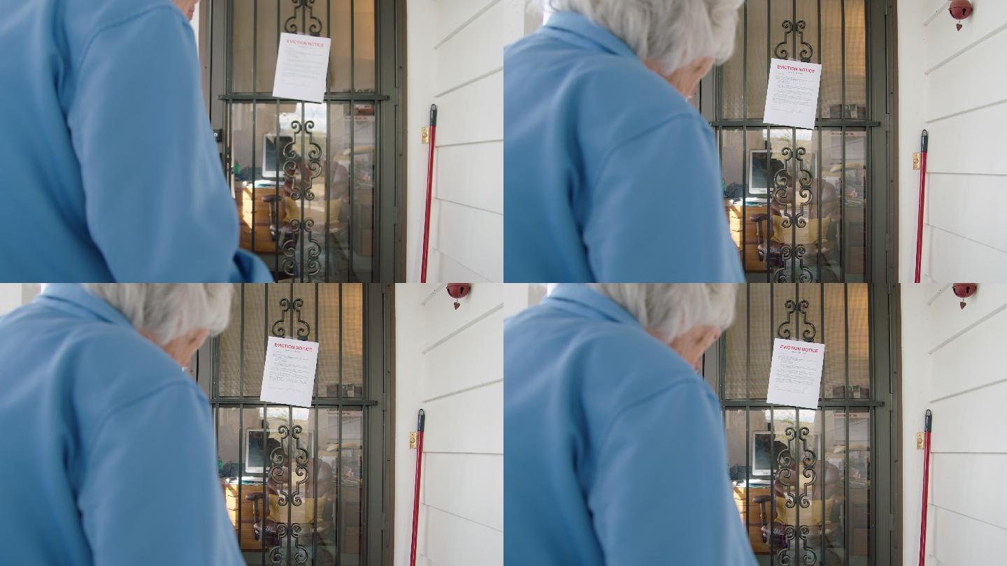 一位100岁的老妇人站在一所房子的前门上，手里拿着一个移动式助行器，看着一张驱逐通知