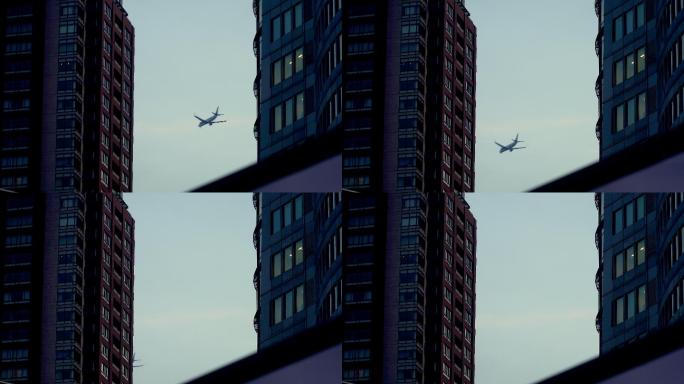 黄昏时在建筑物之间飞行的飞机。东京六本木的城市风光