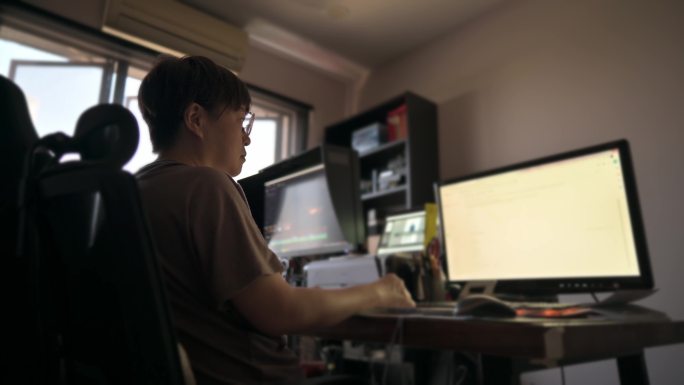 亚裔中国中年女性在家工作，使用多屏幕e-learning