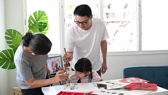 亚洲祖母指导并教她的孙女正确地握毛笔书写好的中国传统书法。