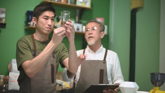 中国亚裔男咖啡师咖啡馆老板与员工在咖啡馆接受冷泡咖啡点滴培训