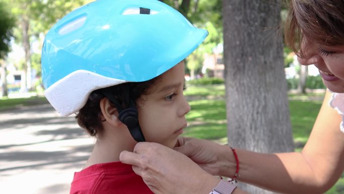 母亲给儿子戴自行车头盔
