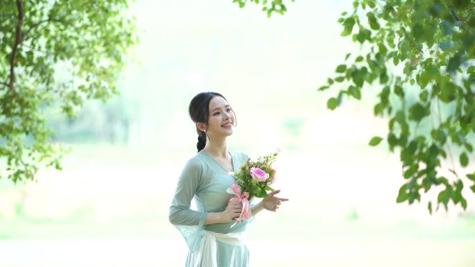 女孩拿着鲜花在树林下