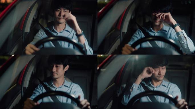 一名亚洲男子晚上开车回家时筋疲力尽。