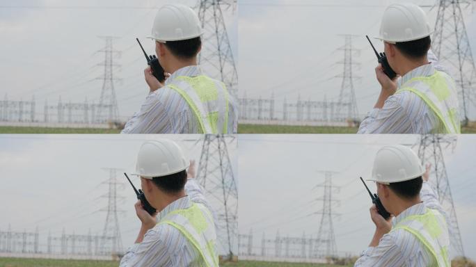 亚洲男子站在无线电工作高压杆上