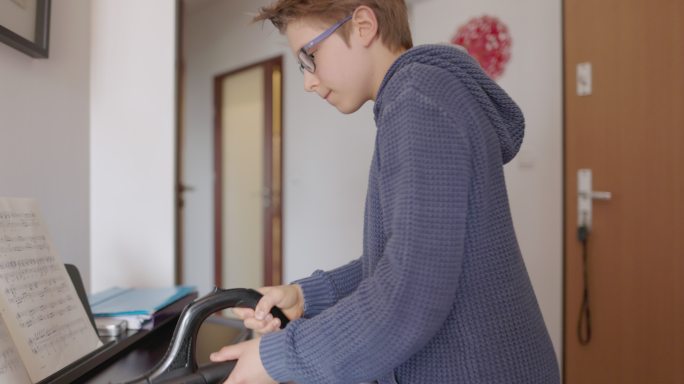 小男孩在家用吸尘器清理钢琴