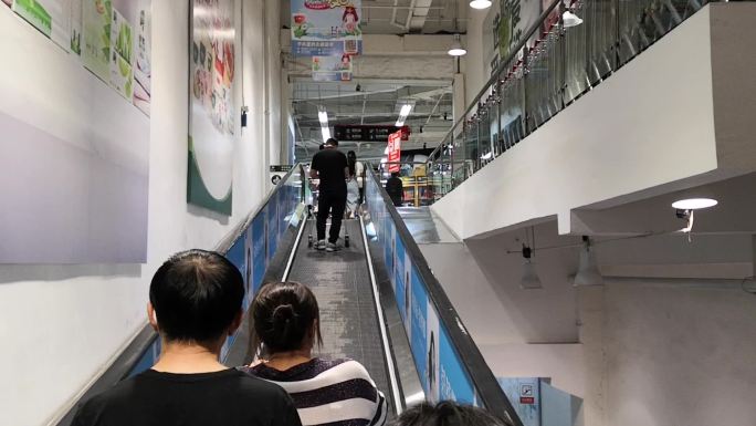 逛超市坐扶梯去二楼上扶梯购物的人