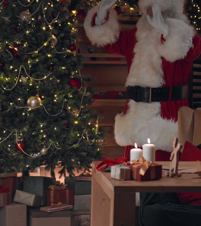 圣诞老人把玩具挂在圣诞树上，然后坐在椅子上
