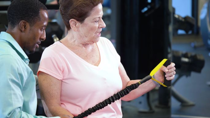 物理治疗师帮助老年女性加强手臂