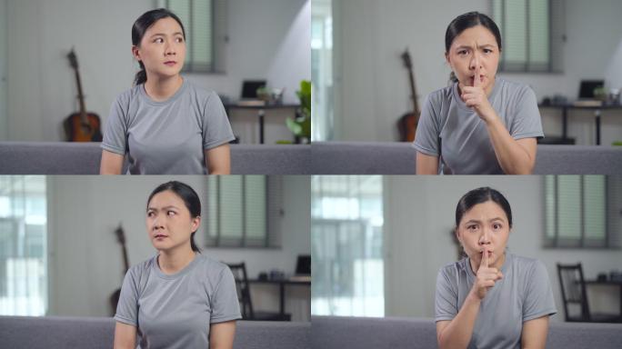亚洲女性把食指放在嘴唇上意味着坐在家里的沙发上保守秘密。