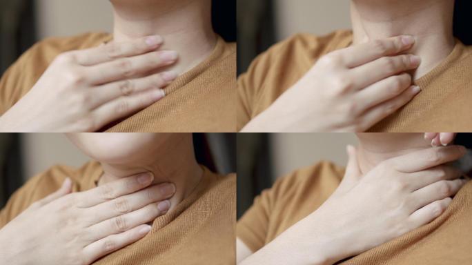 特写亚洲女性在家中接受冠状病毒检疫时，用手抚摸和按摩颈部，以免因疼痛病毒感染或感冒而导致疼痛。