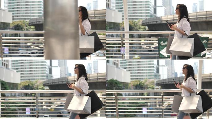 购物日结束后，亚洲女性拿着购物袋行走