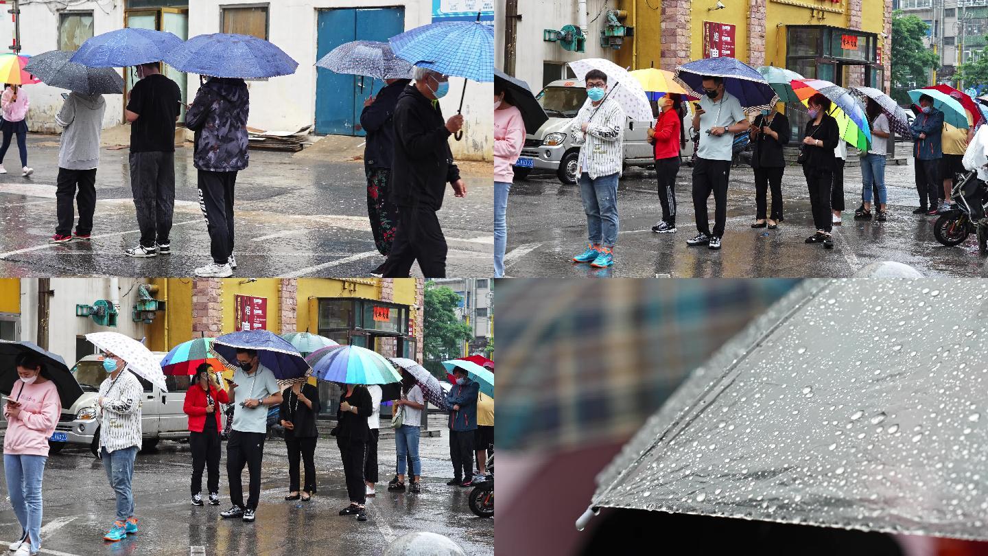 城市大雨中打伞排队的市民人群