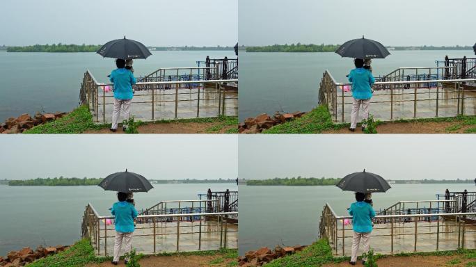 姥姥雨中打伞抱小孩看海