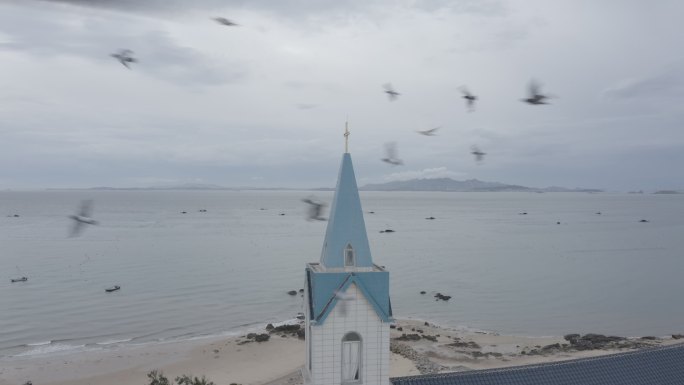 莆田南日岛海边教堂礼拜堂鸽子飞过日落