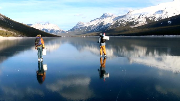 朋友们沿着结冰的阿尔卑斯湖滑冰，钓到冰鱼