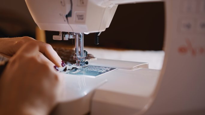 斯洛·莫面目全非的女裁缝用缝纫机缝纫