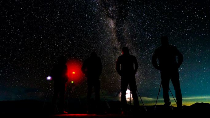 延时长短摄影师在夜山上拍摄银河和恒星轨迹。