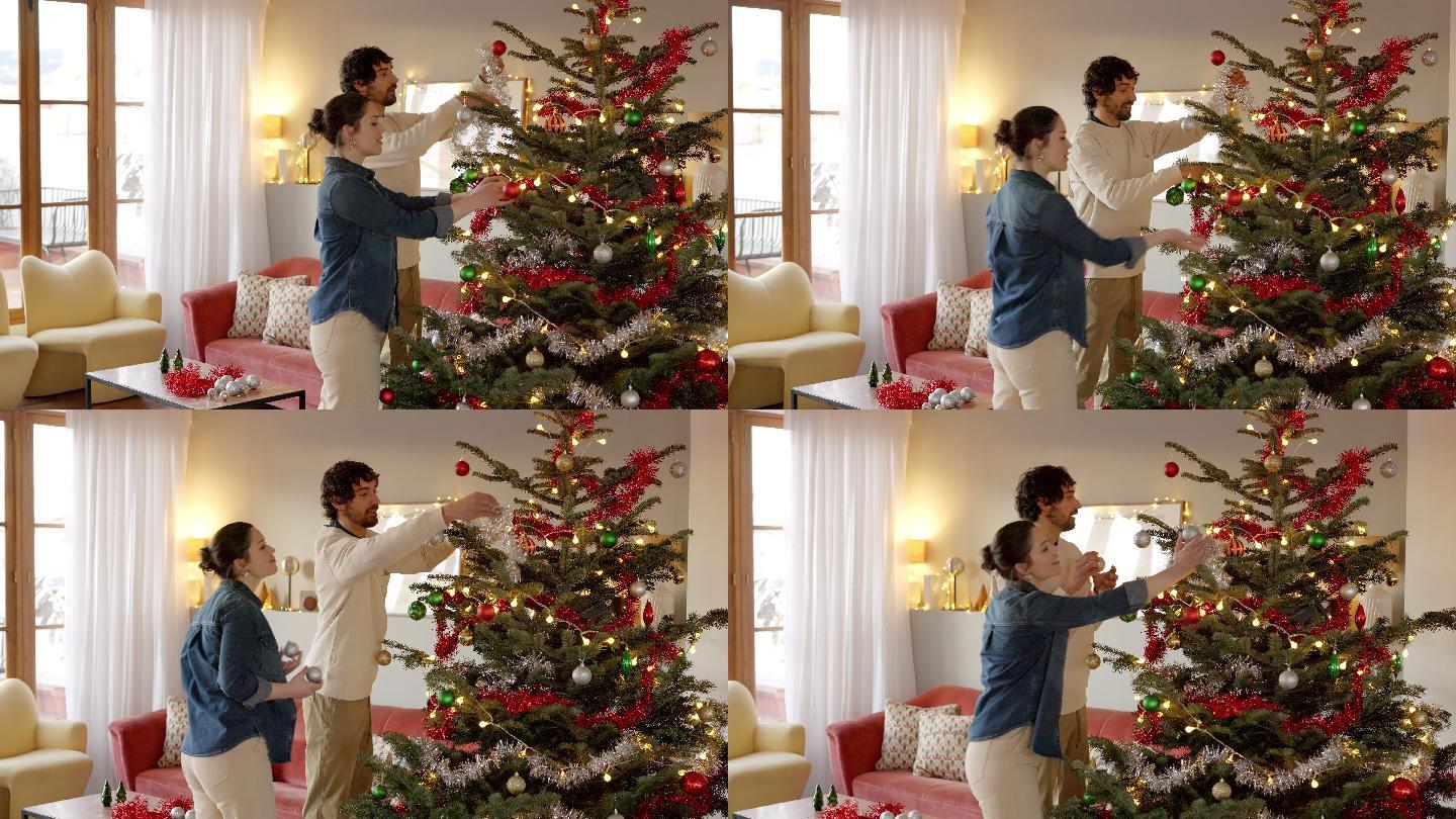 夫妻俩在家里用不同的装饰品装饰圣诞树
