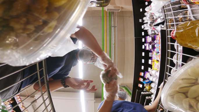 一对亚裔中国异性恋夫妇在超市将乳制品杂货直接放进购物车