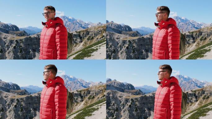 男性徒步旅行者登上山顶，欣赏阿尔卑斯山美丽的山脉