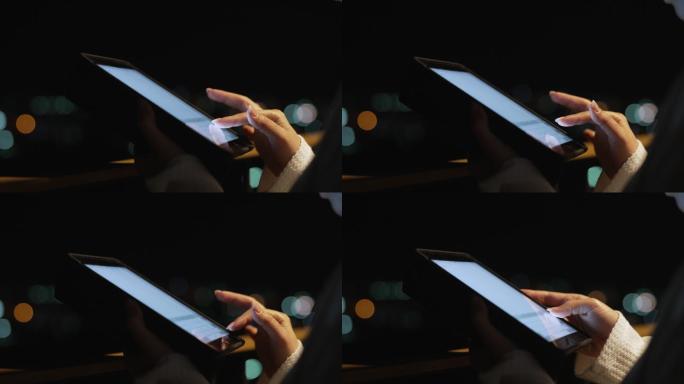 夜间使用数码平板电脑的女性特写镜头