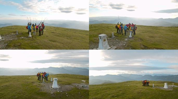 一队空中徒步旅行者在到达山顶后成功地举起了他们的登山杖