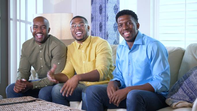 三名非裔美国人微笑着，指着摄像机