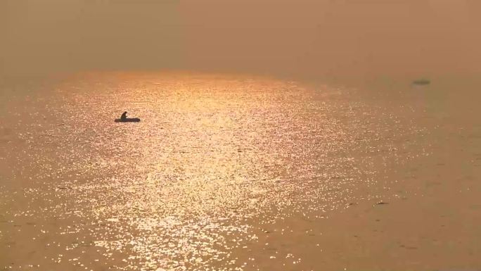 落日的海边孤舟垂钓的老翁