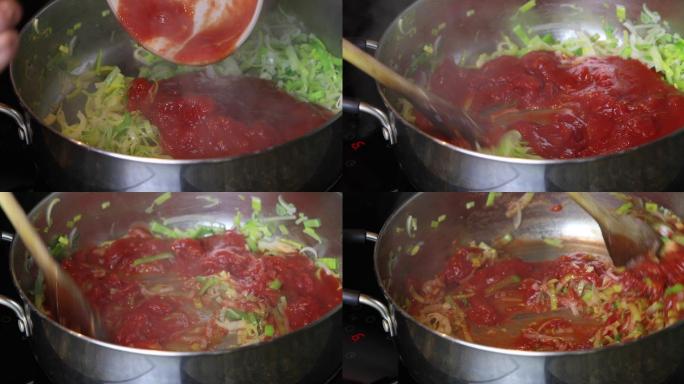 将切好的西红柿倒在大煎锅里炸韭菜上，然后用木勺搅拌