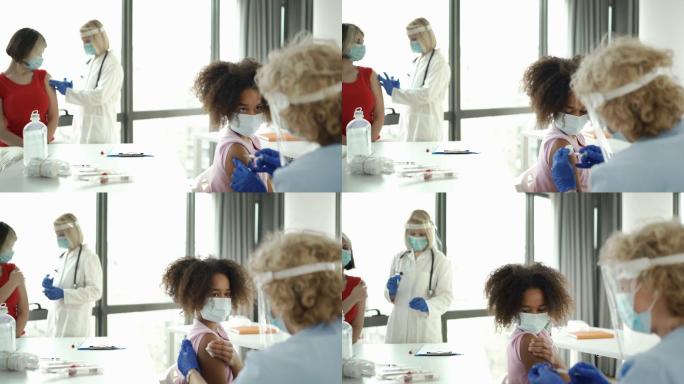 接受新冠肺炎疫苗的小女孩。